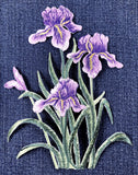 Embroidered patch of purple iris flowers on a dark fabric background