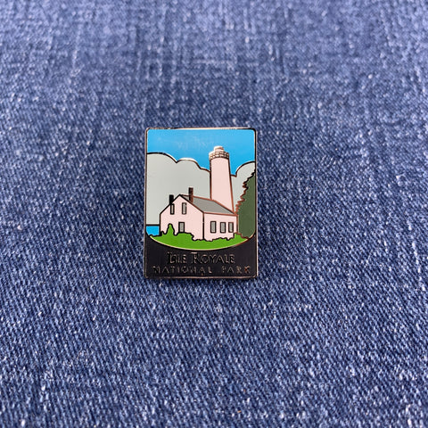 Pin with a Isle Royale National Park lighthouse design on a denim background