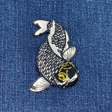 Embroidered fish patch on a denim background
