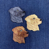 Three embroidered Labrador retriever dog head patches on a denim fabric background