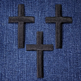 Three black crosses on a blue denim background