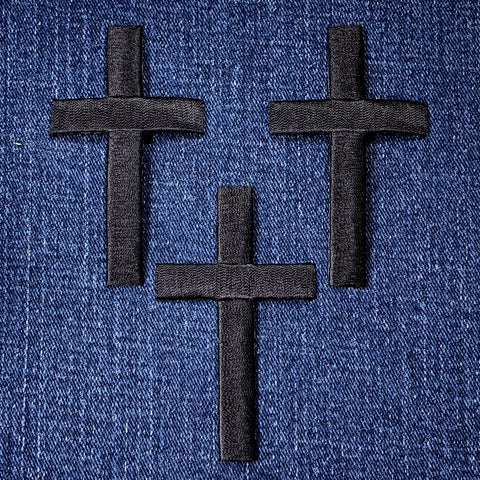 Three black crosses on a blue denim background