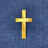 gold cross patch on a denim background