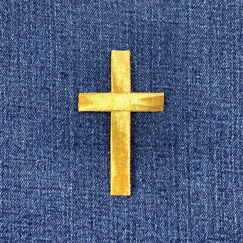 gold cross patch on a denim background