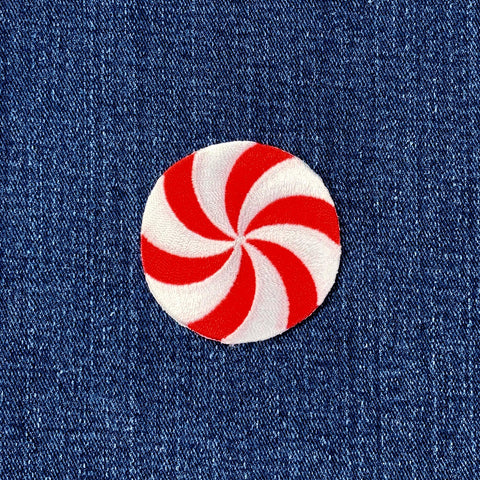 Red and white peppermint candy patch on blue denim fabric