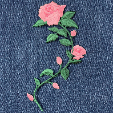 Embroidered pink rose patch on denim fabric