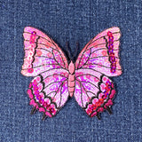 Pink butterfly patch with sequins on denim fabric