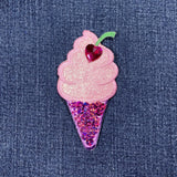 Pink sequin ice cream cone patch with a heart on denim fabric