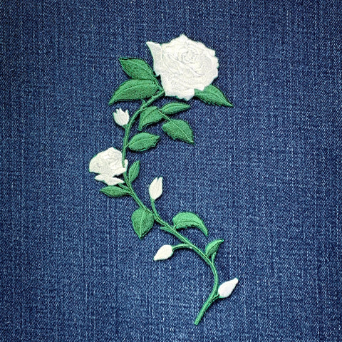 Embroidered white flower patch on a blue denim fabric