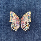 Butterfly patch with colorful wings on denim fabric