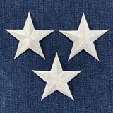 Three white star patches on a blue denim background