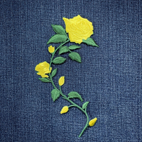 Embroidered yellow rose patch on denim fabric
