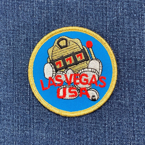 Embroidered patch of a robot with 'Las Vegas USA' text on denim fabric
