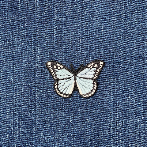 Light blue butterfly patch on denim fabric