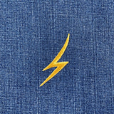 gold lightning bolt embroidered patch on blue denim fabric