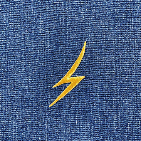 gold lightning bolt embroidered patch on blue denim fabric