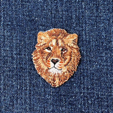 Embroidered lion patch on denim fabric
