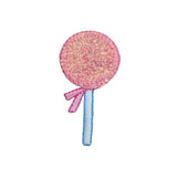 Pink glittery lollipop-shaped patch with a blue handle on a white background