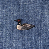 a single loon patch on a denim background