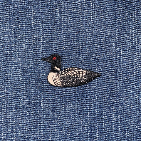 Embroidered loon patch on denim fabric