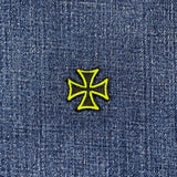 neon green and black cross patch on blue denim fabric