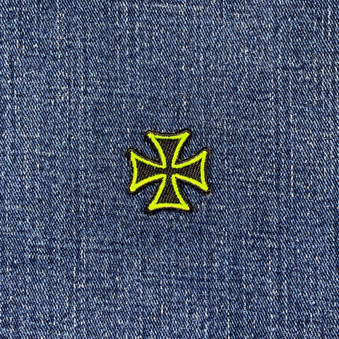neon green and black cross patch on blue denim fabric