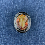 An oval medallion with a depiction of Mammoth Cave National Park, designed to be attached to a walking stick on a denim background