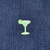 Green cocktail glass patch on blue denim fabric