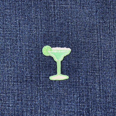 Green cocktail glass patch on blue denim fabric