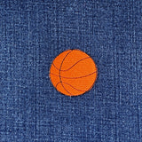 Orange basketball patch on blue denim fabric