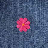 Pink flower patch on blue denim fabric