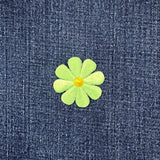 Green flower patch on blue denim fabric