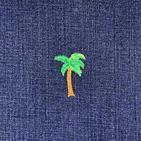 Embroidered palm tree patch on denim fabric