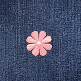 Pink flower-shaped patch on a denim background