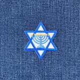 Star of David patch with a menorah design on blue denim fabric