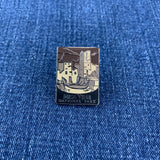 Pin with a design of a mesa verde national park mountain and buildings on a blue denim background