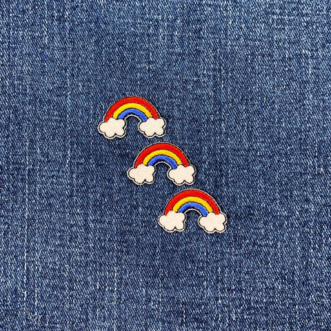Three rainbow and cloud patches on a denim background