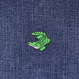 Green alligator patch on blue denim fabric