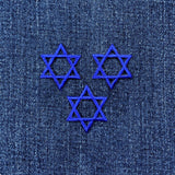 Three blue Star of David patches on denim fabric