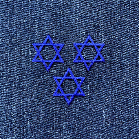 Three blue Star of David patches on denim fabric