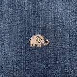 Embroidered elephant patch on a denim fabric background