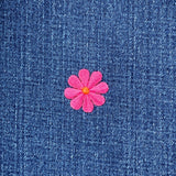 Pink flower patch on blue denim fabric