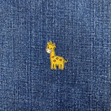 Embroidered giraffe patch on a denim fabric background