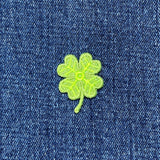 green 4 leaf clover patch on a denim background