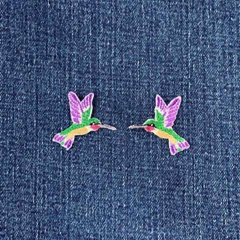 Colorful hummingbird patches on a denim background