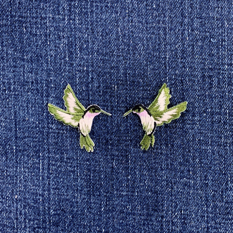 Pair of hummingbird patches on a denim background