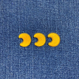Yellow moon phase patches on a blue denim background