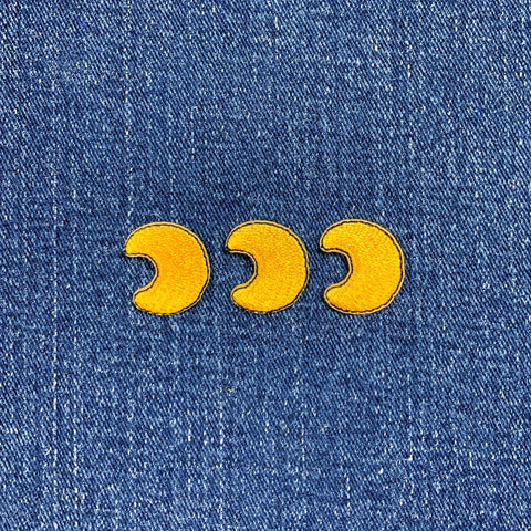 Yellow moon phase patches on a blue denim background