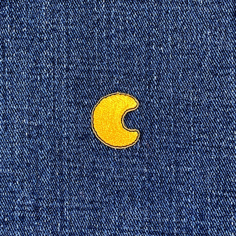Yellow crescent moon patch on blue denim fabric