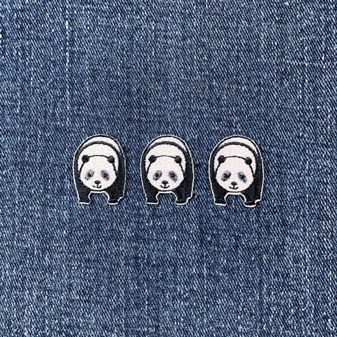 Three panda-shaped patches on a denim background